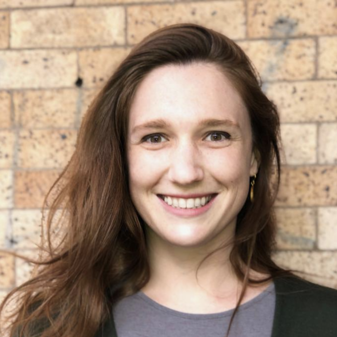 Woman in front of brick wall